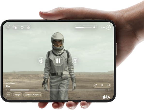 iPhone Duo, lo sostiene una mano, abierto en posición horizontal, completamente desplegado, la pantalla interior muestra la serie "Silo" de Apple TV